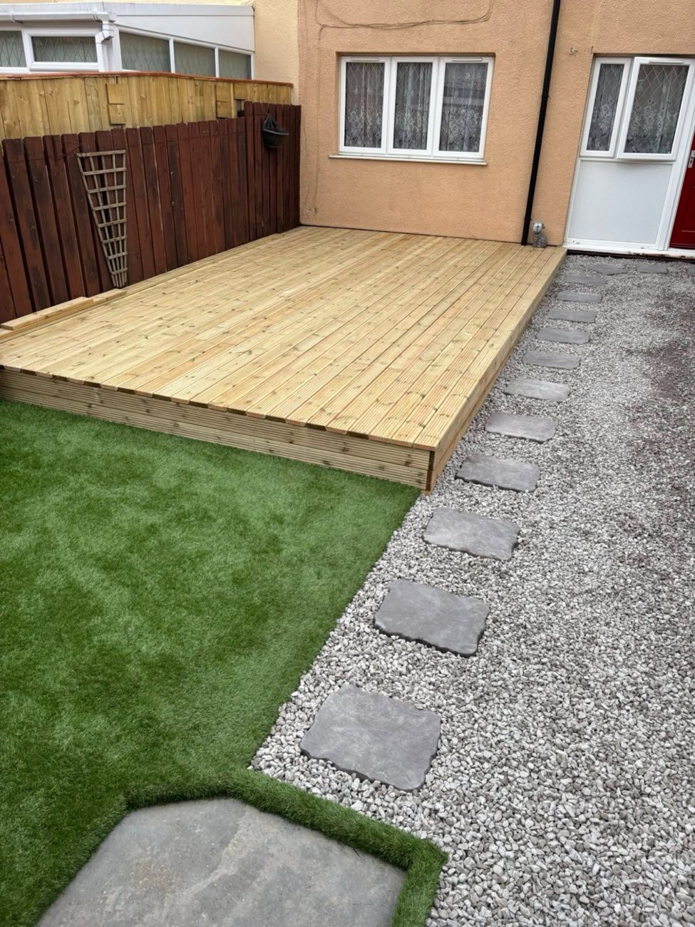Raised decking with artificial turf and slate stepping stones
